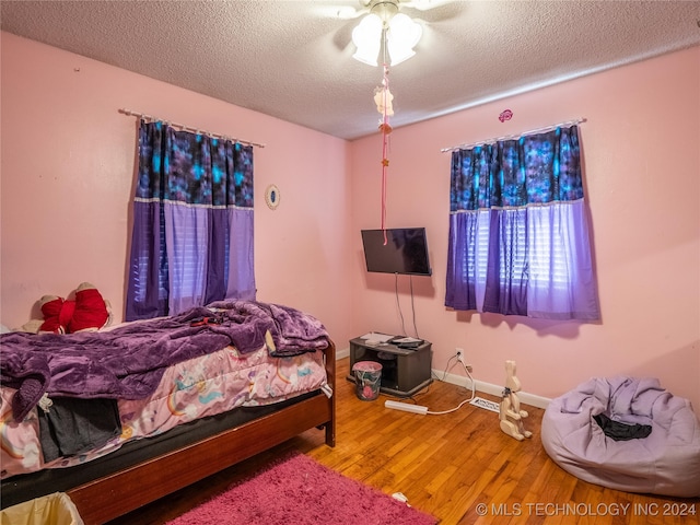 bedroom featuring a textured ceiling, ceiling fan, and hardwood / wood-style flooring