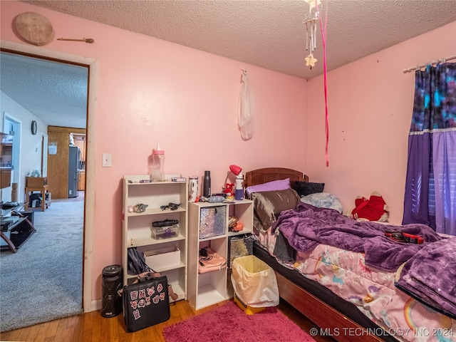 bedroom with wood-type flooring and a textured ceiling