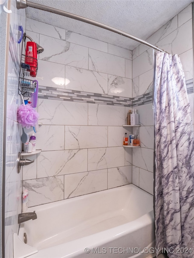 bathroom with a textured ceiling and shower / tub combo