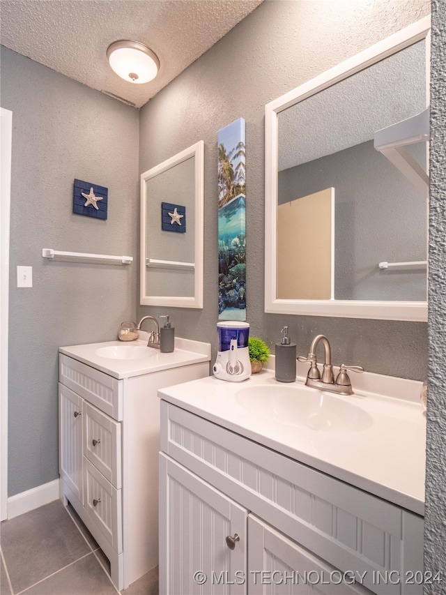 bathroom featuring vanity, tile patterned flooring, and a textured ceiling