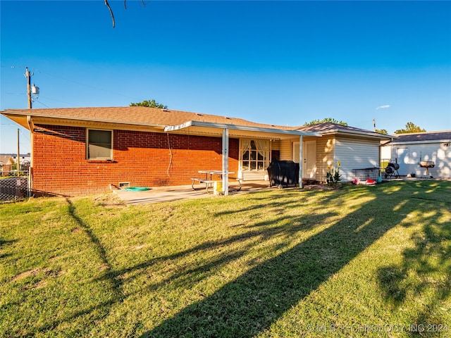 back of house featuring a patio and a yard