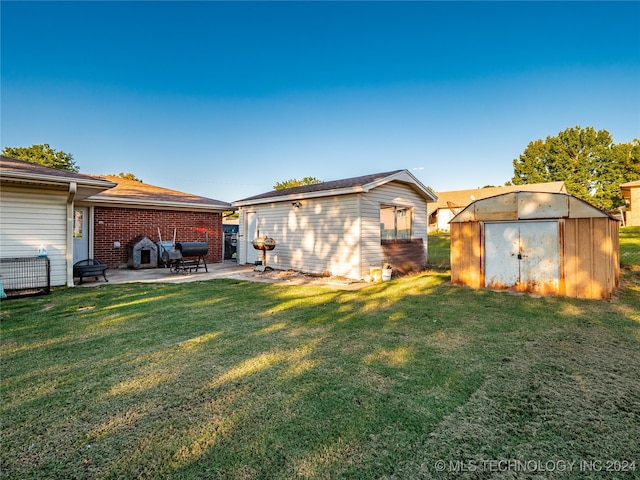 rear view of property featuring a storage shed, a patio, and a yard