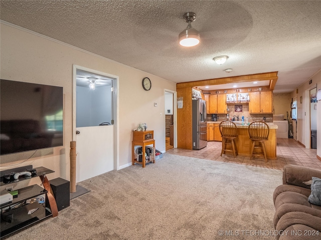 living room featuring a textured ceiling, light colored carpet, and bar