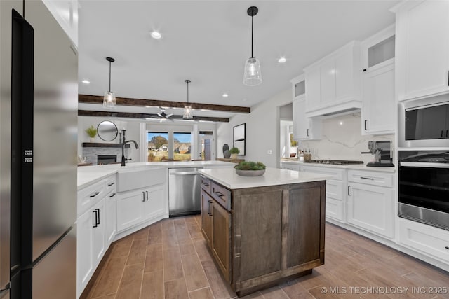 kitchen featuring white cabinetry, beam ceiling, stainless steel appliances, and kitchen peninsula