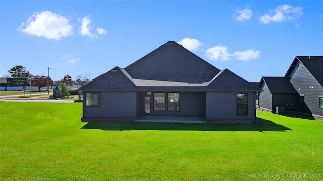 rear view of property with a yard and a patio