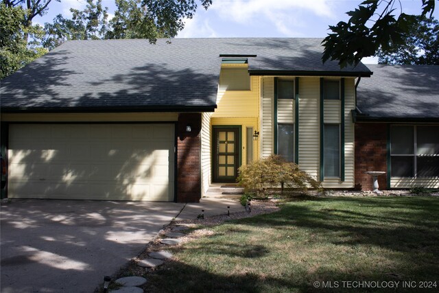 view of front of house with a front yard and a garage