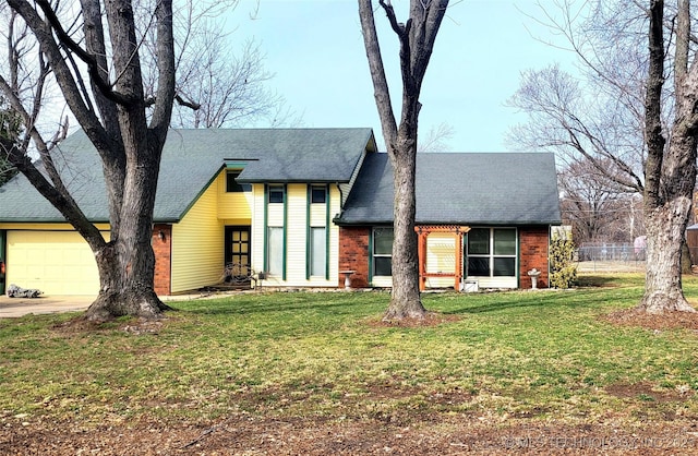 view of front of home featuring a front yard, concrete driveway, roof with shingles, and an attached garage