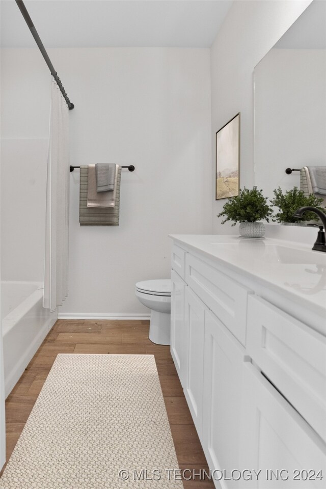 full bathroom featuring vanity, toilet, shower / tub combo with curtain, and hardwood / wood-style floors