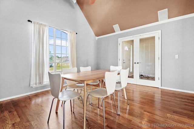 dining area with french doors, hardwood / wood-style flooring, and high vaulted ceiling