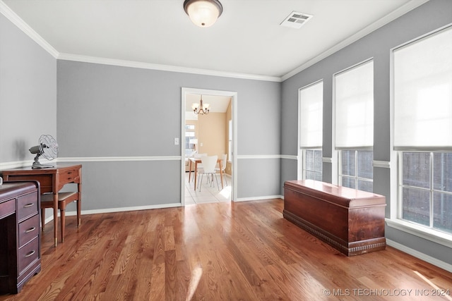 interior space with an inviting chandelier, wood-type flooring, and ornamental molding