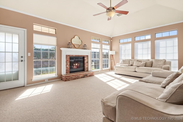 carpeted living room featuring ceiling fan, a brick fireplace, ornamental molding, and a healthy amount of sunlight