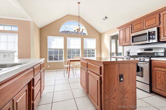 kitchen with a chandelier, appliances with stainless steel finishes, plenty of natural light, and a kitchen island