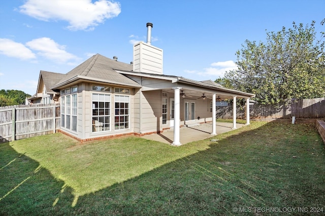 back of property with ceiling fan, a yard, and a patio area