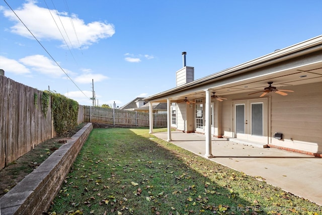 view of yard featuring ceiling fan, a patio area, and french doors