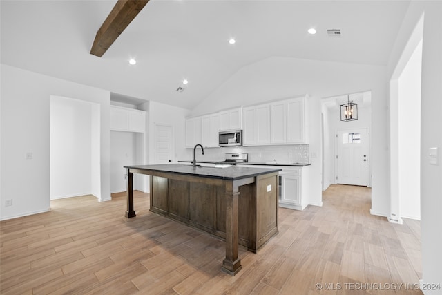 kitchen with appliances with stainless steel finishes, light wood-type flooring, white cabinetry, and an island with sink