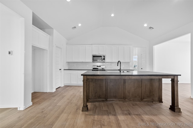 kitchen with a center island with sink, white range, white cabinets, and light wood-type flooring