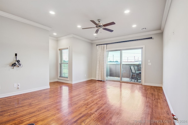 empty room featuring ceiling fan, ornamental molding, hardwood / wood-style floors, and a wealth of natural light