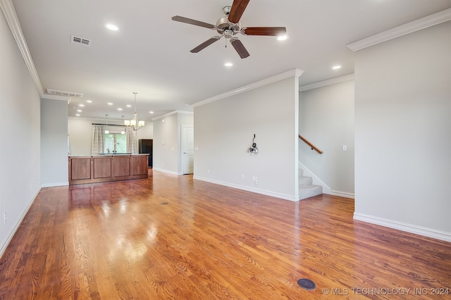 unfurnished living room with ceiling fan with notable chandelier, hardwood / wood-style floors, and ornamental molding