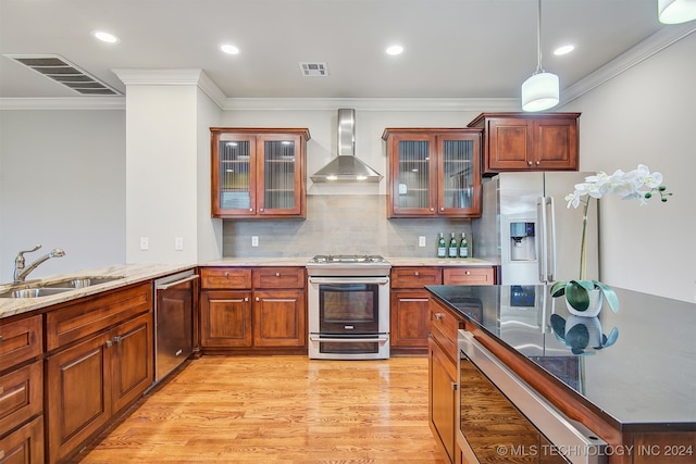 kitchen with light hardwood / wood-style floors, tasteful backsplash, stainless steel appliances, sink, and wall chimney range hood