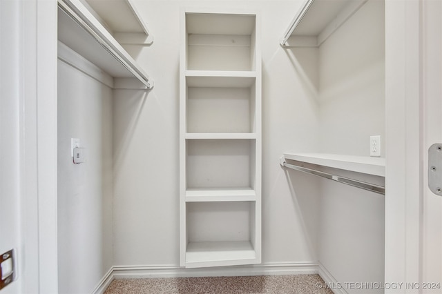 walk in closet with carpet floors