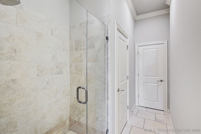 bathroom featuring ornamental molding, tile patterned flooring, and walk in shower