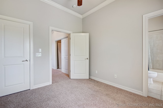 unfurnished bedroom featuring crown molding, ensuite bath, ceiling fan, and light colored carpet