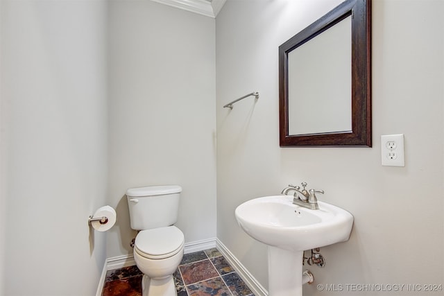 bathroom featuring ornamental molding and toilet