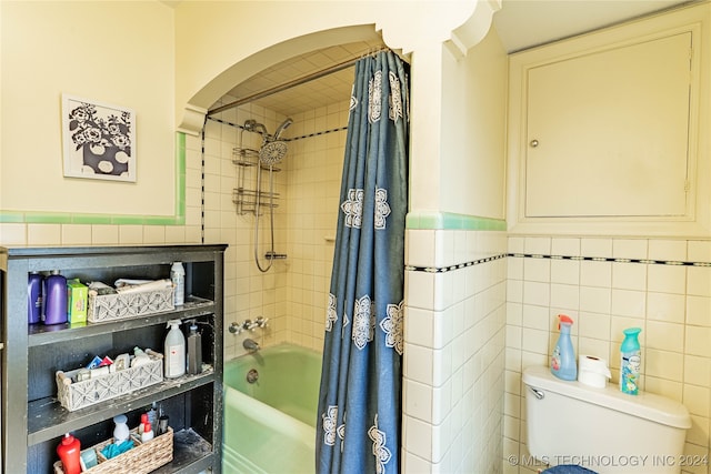 bathroom featuring tile walls, toilet, and shower / bath combination with curtain