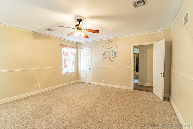 empty room featuring ornamental molding, ceiling fan, and carpet floors