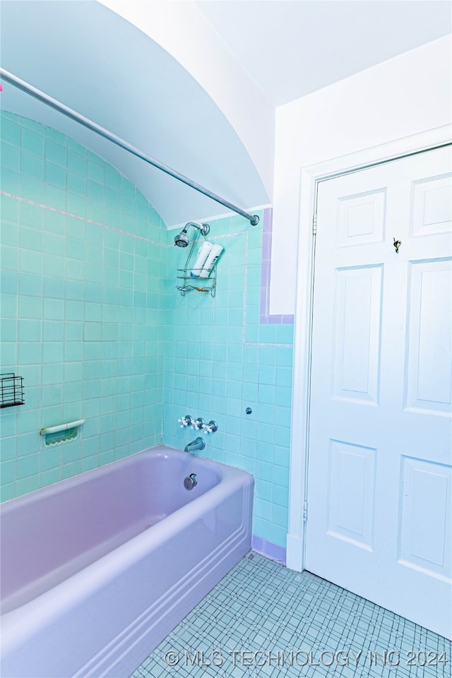 bathroom with tiled shower / bath, tile walls, and tile patterned floors