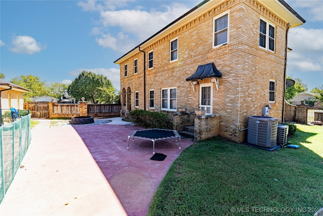 rear view of house with a yard, central AC unit, and a patio area