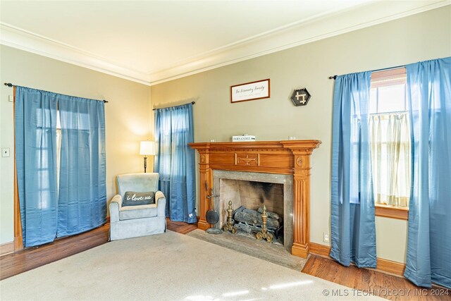 unfurnished living room featuring wood-type flooring and ornamental molding