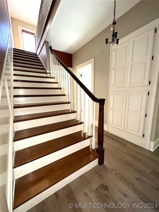 stairway with a chandelier and hardwood / wood-style floors