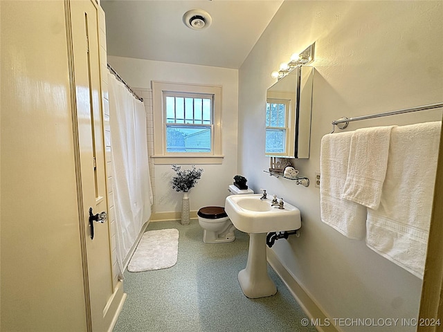 bathroom featuring a shower with curtain and toilet