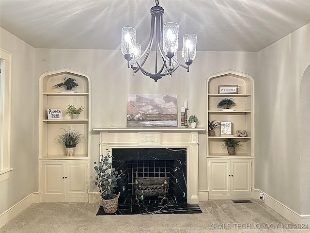 carpeted living room featuring built in shelves, a textured ceiling, and a chandelier