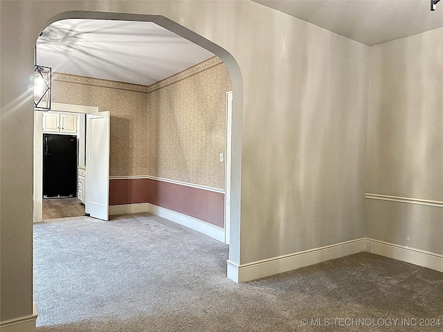 420 K St SW, Ardmore, OK 73401 - carpeted spare room with arched walkways, wallpapered walls, and baseboards
