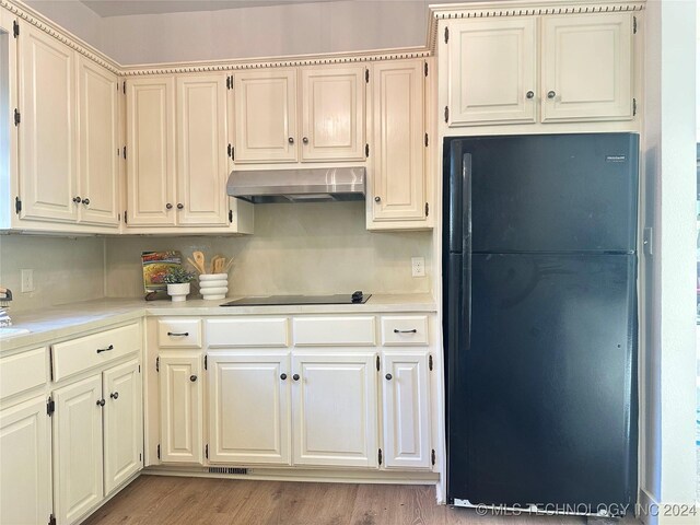 420 K St SW, Ardmore, OK 73401 - kitchen with black appliances, exhaust hood, light countertops, and light wood-style flooring