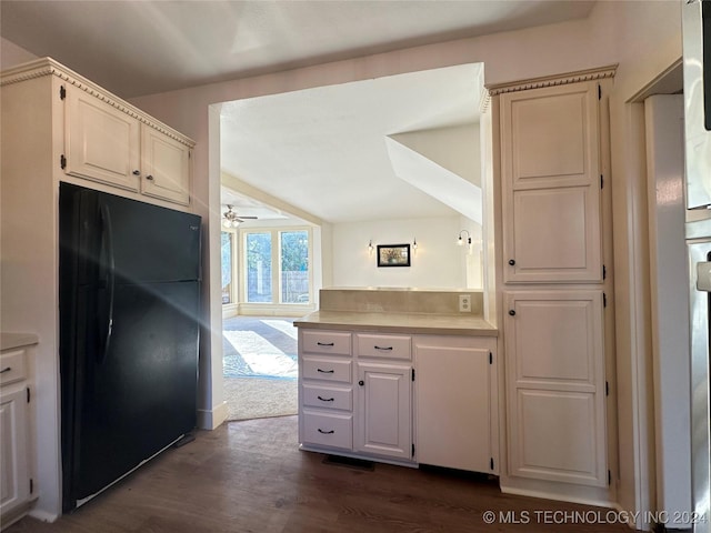 kitchen with white cabinetry, black fridge, ceiling fan, and dark wood-type flooring