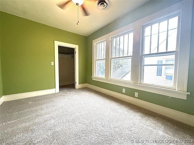 spare room featuring ceiling fan and carpet