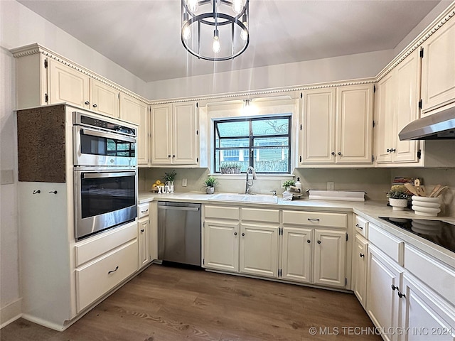 kitchen featuring dark wood-type flooring, an inviting chandelier, sink, white cabinetry, and stainless steel appliances