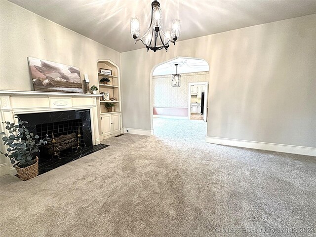 unfurnished living room with a notable chandelier, built in features, and light carpet