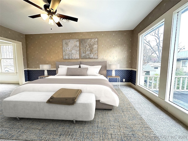 bedroom featuring ceiling fan, carpet floors, and multiple windows