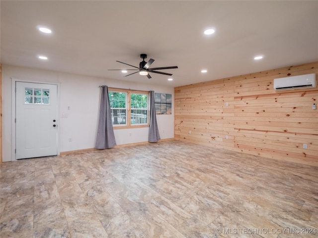 interior space with wooden walls, ceiling fan, and a wall mounted air conditioner