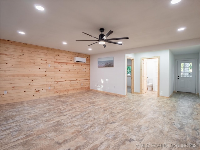 empty room with ceiling fan, wooden walls, and a wall unit AC