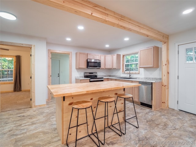 kitchen with light brown cabinets, appliances with stainless steel finishes, sink, and wooden counters