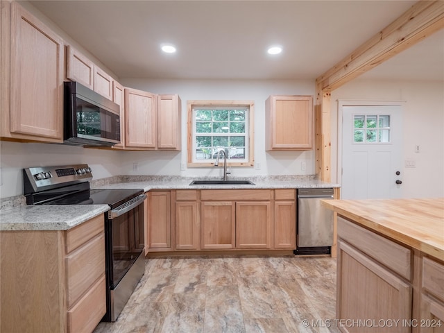 kitchen with stainless steel appliances, light brown cabinets, and sink