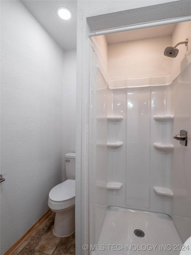 bathroom with walk in shower and toilet