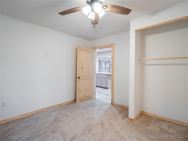 unfurnished bedroom with ceiling fan, a closet, and light carpet