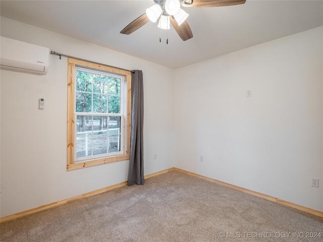 empty room featuring a wall unit AC, ceiling fan, and light colored carpet