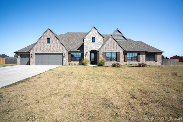 view of front of home with a garage and a front lawn